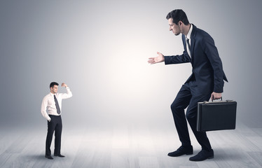 Big debutant young businessman scared of small strong businessman
