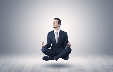 Businessman levitates and sitting in yoga position in an empty infinity space
