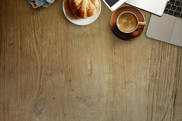 Office desk wood table with computer, supplies, flower and coffee cup. Top view with copy space