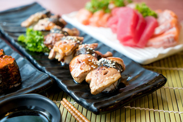Sushi with chopsticks and soy sauce. Sushi roll japanese food in restaurant. Foie Gras Sushi set with salmon, tuna, flying fish roe and caviar closeup. Japan restaurant menu.