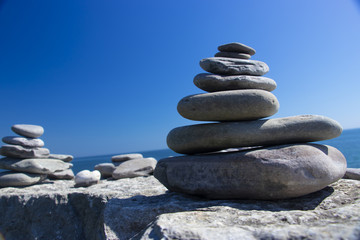 Stones shaped into an inukshuk by the beach along the sea shoreline