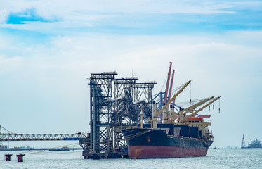 Bulk Vessel alongside at sea port terminal by loading with conveyor, general bulk vessel loading...