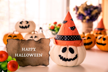 White and yellow ghost pumpkins with witch hat and Happy halloween text on borad. halloween concept.