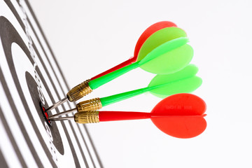 Close up shot green and red darts arrows in the target center. Business target or goal success and winner concept.