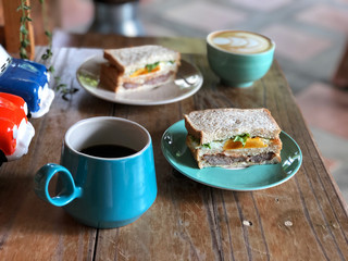 Healthy Breakfast with special one, Homemade fresh sandwich and coffee cup on green plate set. Black coffee and Latte art coffee.