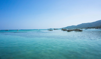 Fototapeta na wymiar a green sea with beautiful island and blue sky as background in karimun jawa