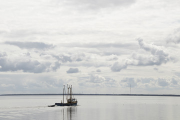 Fishing boat is emptying the nets, placed along the Aflsluitdijk in a calm peacfull IJsslemeer