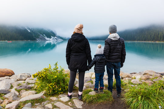 Young family admiring the view at Lake Louise on a foggy day