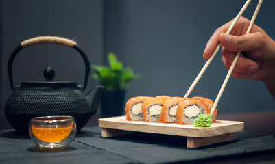 Philadelphia roll on wooden plate and fruit tea © Irina