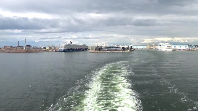 The farry ship leaves the port, leaving a trail on the water
