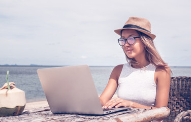 Young woman freelancer working on the beach