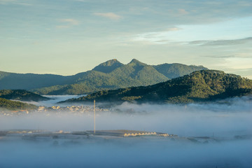 wonderful landscape of Da Lat city, early morning fog covering the city, far away is the green mountains, mist covered the greenhouse under the morning sun