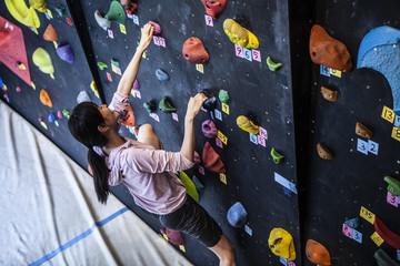 笑顔で壁を登る女性