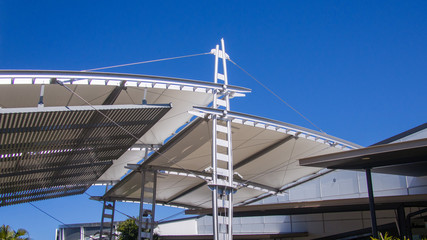 Sail shade pergola made of galvanized steel and stainless steel wire cable tall structure against the blue sky