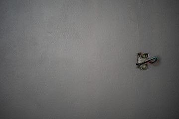 Several exposed copper wires protruding from a beige wall.