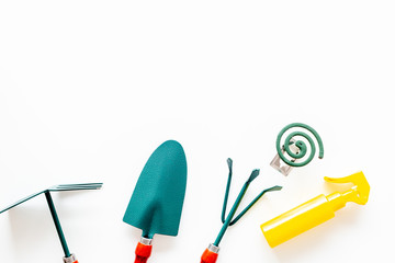 Mosquito protection for garden. Mosquito coil and spray near garden tools on white background top view copy space