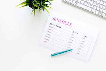 School student's schedule with time of lessons on white office desk with computer keyboard top view copy space