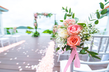 Chair decorated with flowers in Wedding ceremony.