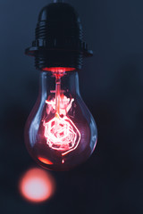 A classic Edison light bulb on dark background with space for text