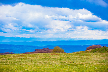 Fototapeta premium Mountain and hill landscape with clouds and fields.