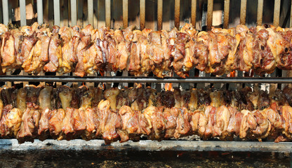 skewer with chicken meat cooking very slowly