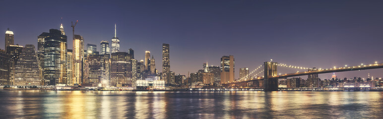Manhattan skyline an the Brooklyn Bridge at night, color toning applied, USA.