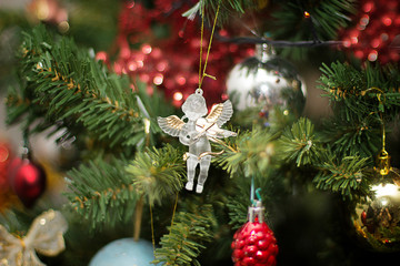 Christmas tree toy angel  with a violin on a Christmas tree with balls and a garland