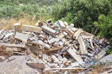 Construction and Demolition Debris. Background of olive trees in summer.