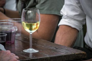wine glass on wooden table with people, delicious italian beverage
