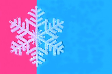 Christmas background, artificial snowflake on blue and magenta colors. 
