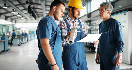 Team Of Engineers Having Discussion In Factory