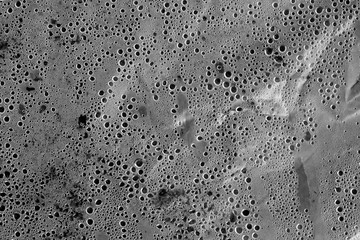 Condensation drops on plastic transparent material in black and white.