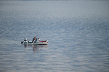 Old traditional fisherman in Croatia on a small wooden boat back into the harbor early morning