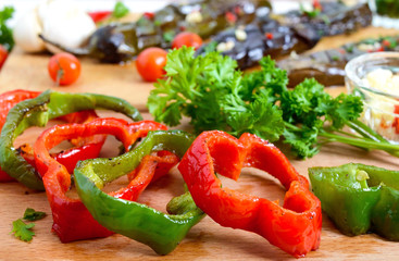 Tasty grilled vegetables - eggplant, sweet pepper with herbs, garlic, tomatoes on wooden boards on a light background.