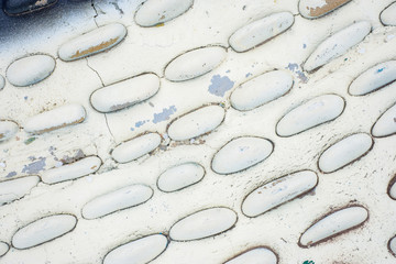 Round stones painted white as the decor of the walls on the street