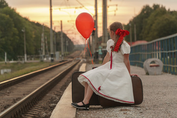 experct a train.The girl is sitting on suitcases