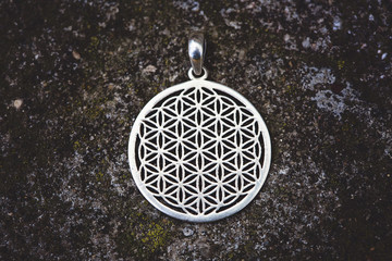 Indian spiritual ornamental style pendant on rocky background
