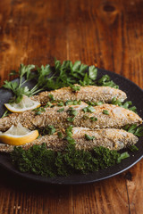 Fried fish in a plate on the wooden table