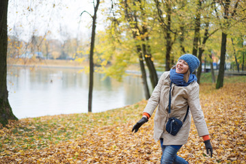 Cheerful young woman in autumn park