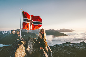 Woman and Norway flag on mountain summit blonde girl traveling enjoying view hiking adventure...