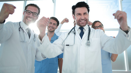 a victory sign of a team of doctors in white coats