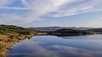 Aerial view of Gruza lake near the village Knic in the Serbia. Reflection of clouds in the lake. Beginning of sunset.