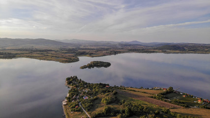 Aerial view of Gruza lake near the village Knic in the Serbia. Reflection of clouds in the lake. Beginning of sunset.