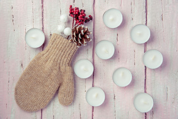 Warm mittens, cones and fir branches on a beautiful pink background