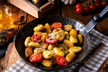 gnocchi baked with green pesto, cherry tomatoes and parmesan