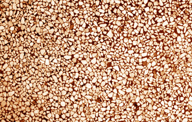 Wall made of small stones in orange tone.