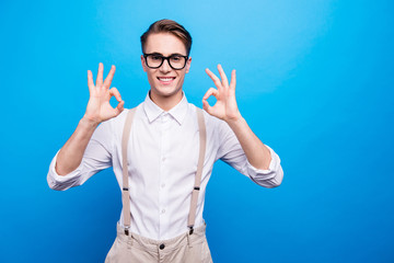 Naklejka premium Portrait of cute, nice-looking youngster man show ok sign, look 