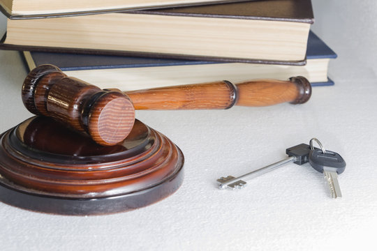 Judge hammer and house key on light background. The concept of property law. Estate sale