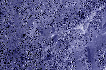 Condensation drops on plastic transparent material in blue tone.