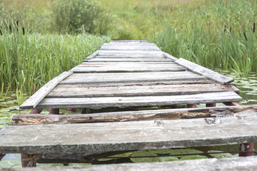 Old leaky bridge near the lake, background
